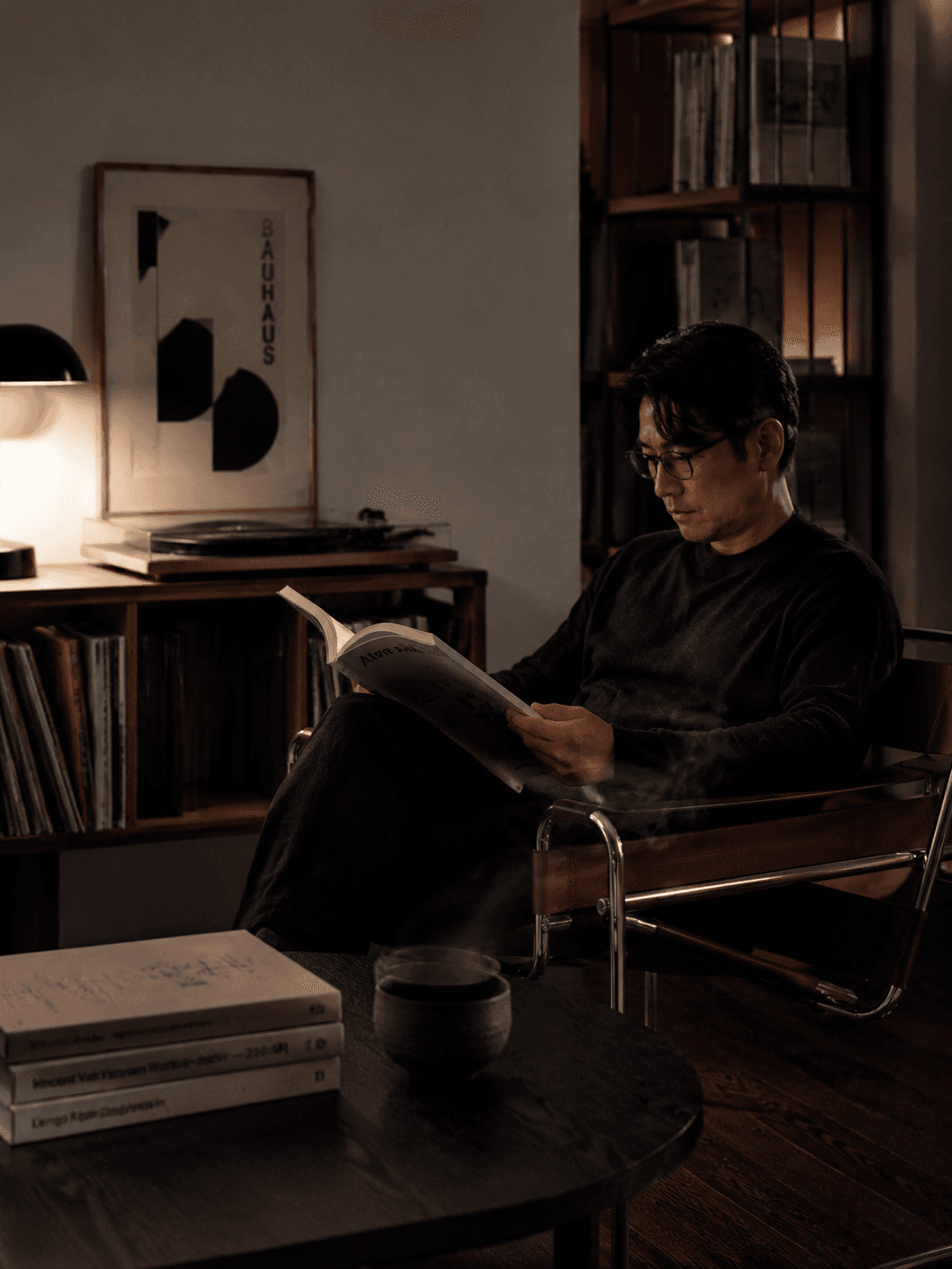 A quiet night study of a Korean male architect in his early 40s, dark brown tone